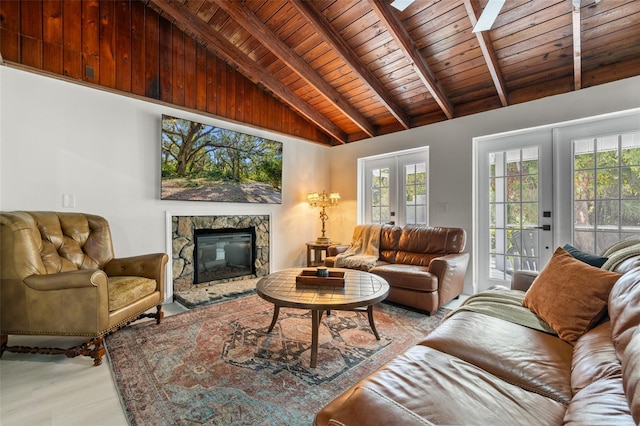 living room featuring french doors, wooden ceiling, beamed ceiling, light hardwood / wood-style floors, and a stone fireplace