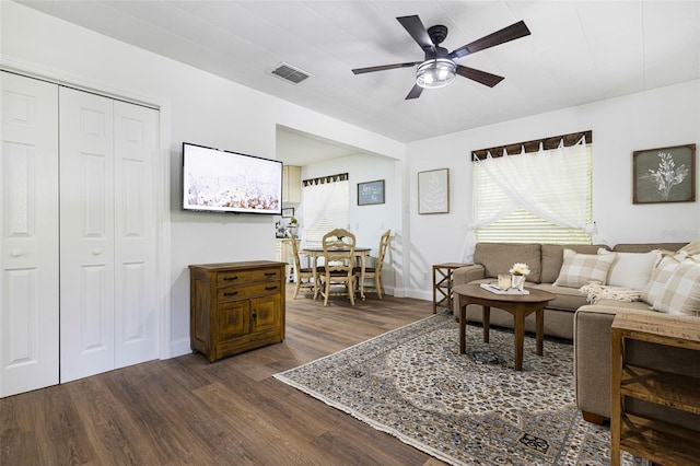 living room with ceiling fan, plenty of natural light, and dark hardwood / wood-style floors