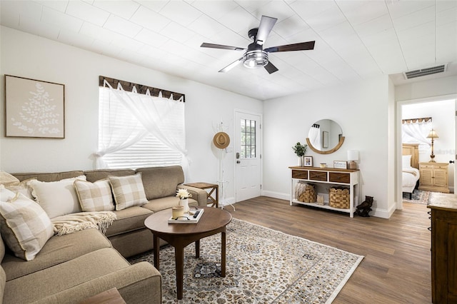 living room with ceiling fan and dark wood-type flooring