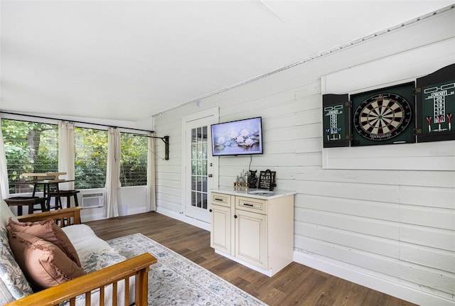 living room with wood walls, dark hardwood / wood-style flooring, and cooling unit