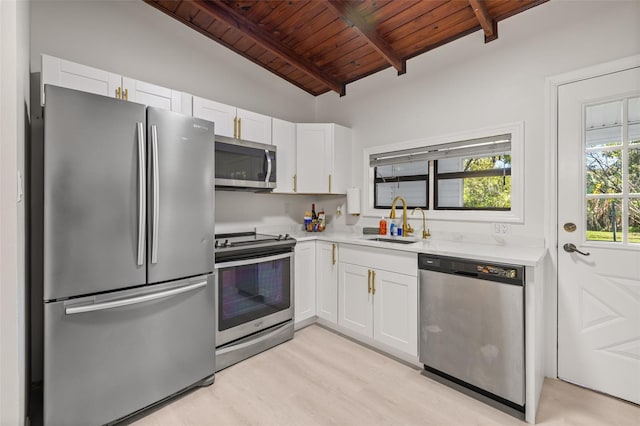 kitchen with stainless steel appliances, sink, lofted ceiling with beams, wooden ceiling, and white cabinetry