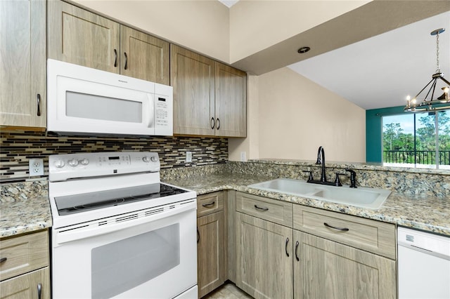 kitchen featuring tasteful backsplash, white appliances, sink, decorative light fixtures, and a chandelier