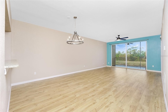 spare room with light hardwood / wood-style flooring and ceiling fan with notable chandelier