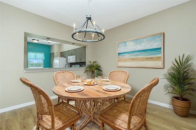 dining room featuring light hardwood / wood-style floors and an inviting chandelier