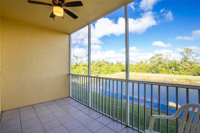 unfurnished sunroom featuring a water view and ceiling fan