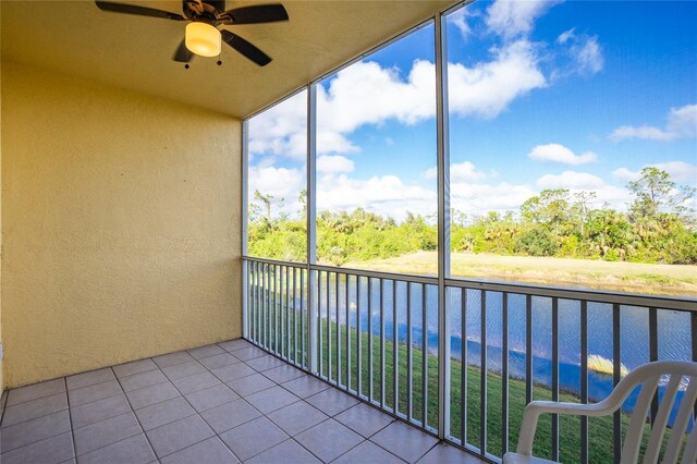 balcony with ceiling fan and a water view