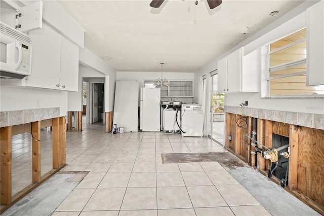 kitchen featuring white appliances, ceiling fan, light tile patterned floors, decorative light fixtures, and white cabinets