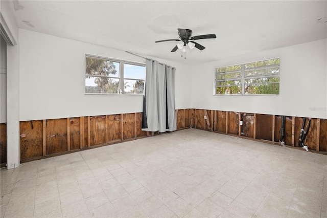 unfurnished room with wood walls and ceiling fan