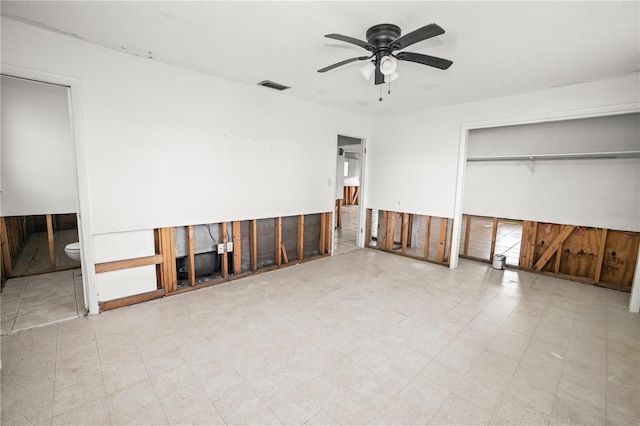 unfurnished bedroom featuring ceiling fan, a closet, and ensuite bath