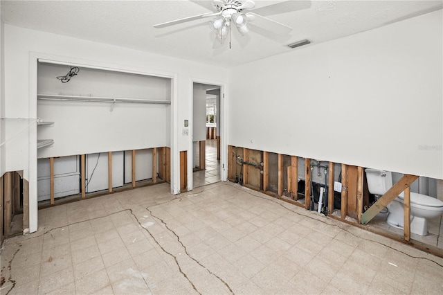 interior space with ceiling fan and a closet