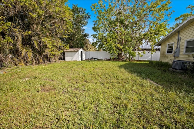 view of yard featuring a storage shed and central air condition unit