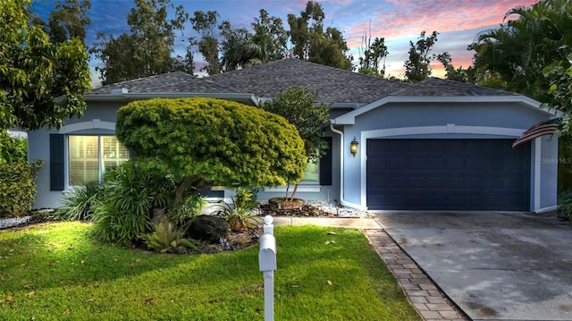 single story home with a garage and a yard