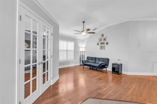 living area featuring french doors, ornamental molding, vaulted ceiling, ceiling fan, and wood-type flooring