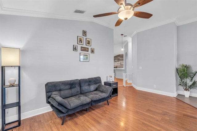 living room featuring hardwood / wood-style flooring, ceiling fan, and ornamental molding