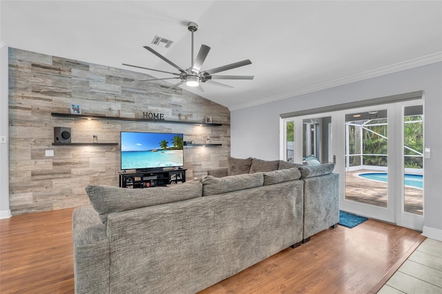 living room with ceiling fan, wood-type flooring, ornamental molding, and lofted ceiling