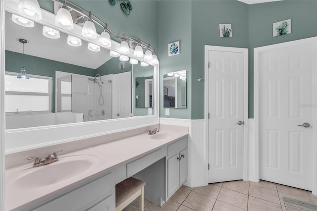 bathroom with tile patterned flooring, vanity, and walk in shower