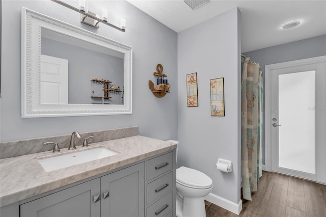 bathroom with wood-type flooring, vanity, and toilet