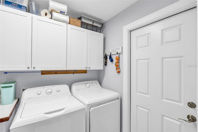 washroom with washing machine and dryer and cabinets