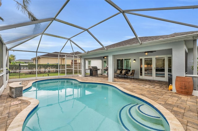 view of pool with a patio, glass enclosure, ceiling fan, and a grill