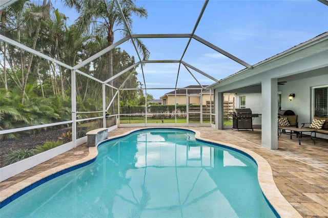 view of pool featuring a lanai, a patio area, and a grill