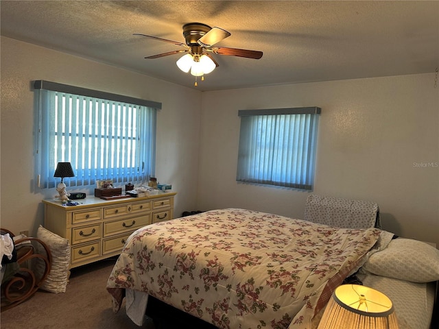 bedroom with dark colored carpet, a textured ceiling, and ceiling fan