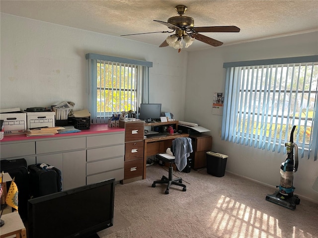 office space with ceiling fan, light colored carpet, and a textured ceiling