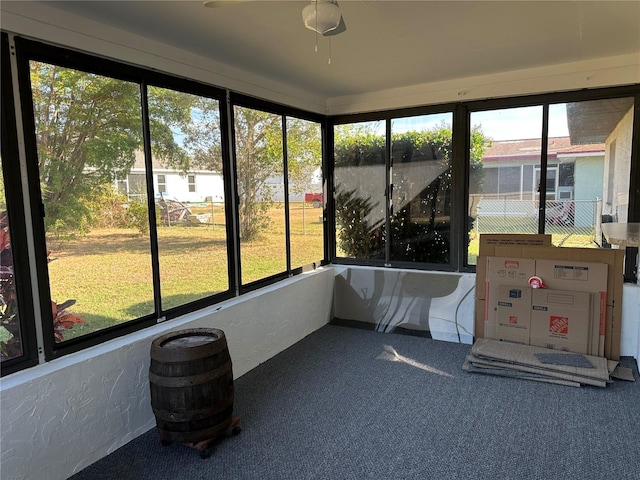 unfurnished sunroom with ceiling fan