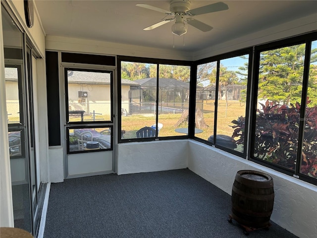 unfurnished sunroom with ceiling fan and plenty of natural light