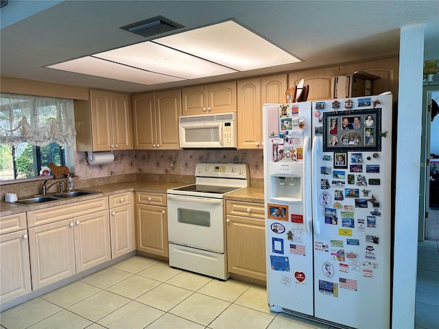 kitchen featuring light brown cabinets, white appliances, sink, and light tile patterned floors