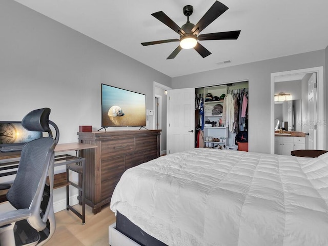 bedroom with visible vents, light wood finished floors, ceiling fan, a closet, and connected bathroom