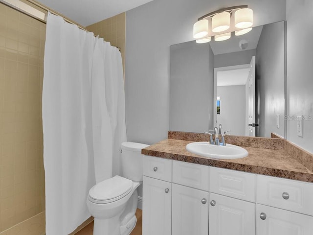 bathroom featuring toilet, vanity, and a tile shower