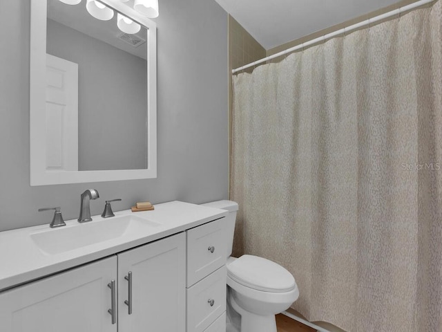 bathroom featuring vanity, toilet, and visible vents