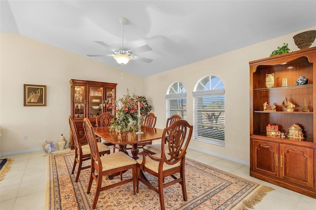 dining room featuring ceiling fan, lofted ceiling, and light tile patterned floors