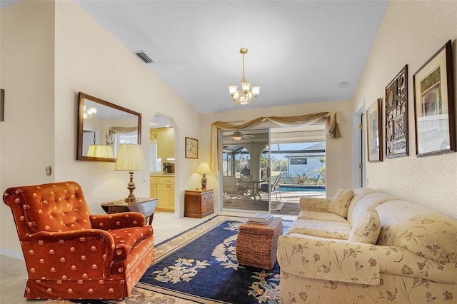 living room featuring a chandelier, vaulted ceiling, and light tile patterned flooring