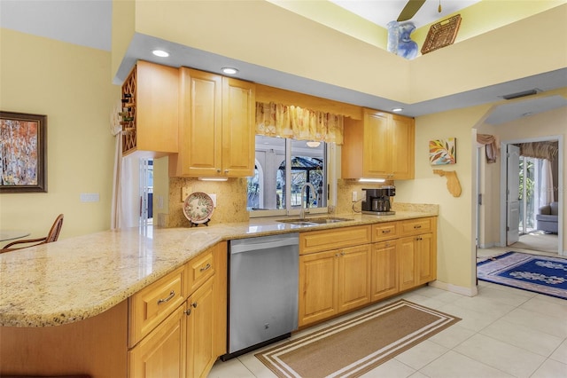 kitchen with kitchen peninsula, stainless steel dishwasher, a wealth of natural light, and sink