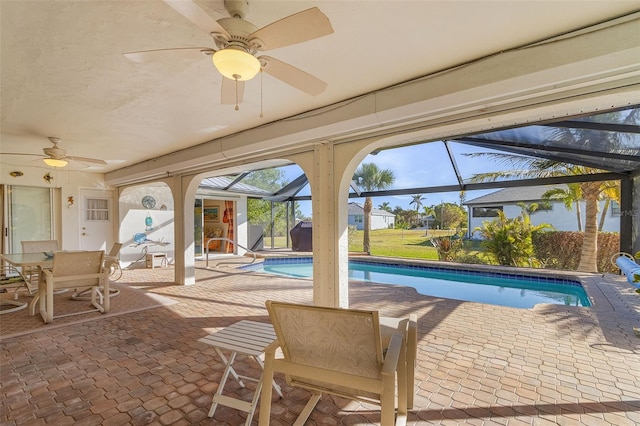 view of swimming pool featuring a patio area, ceiling fan, and glass enclosure