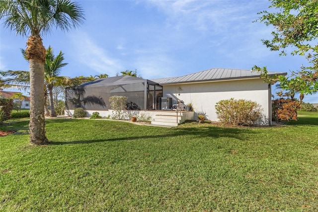 back of property featuring a lanai and a yard