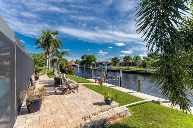 view of patio / terrace featuring a boat dock, a water view, and glass enclosure