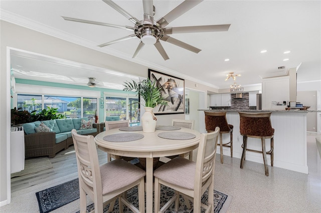 dining area with crown molding and ceiling fan