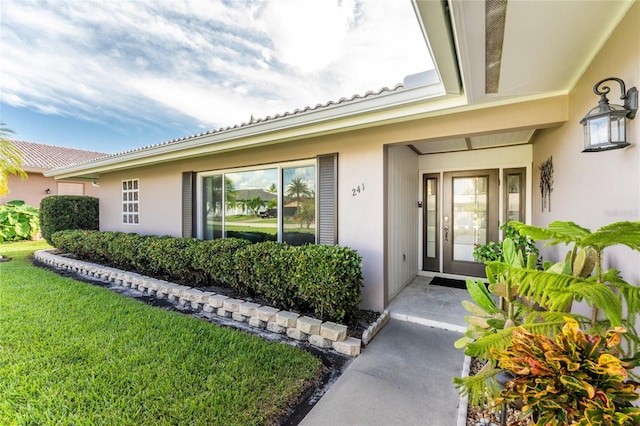 doorway to property with a lawn