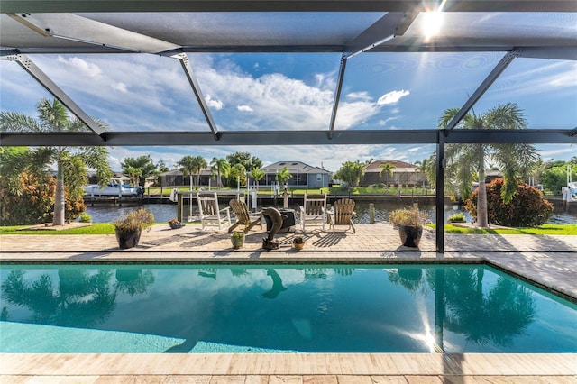 view of pool featuring a patio, a water view, and a lanai