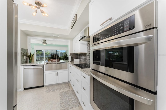 kitchen with light stone counters, ornamental molding, stainless steel appliances, sink, and white cabinets