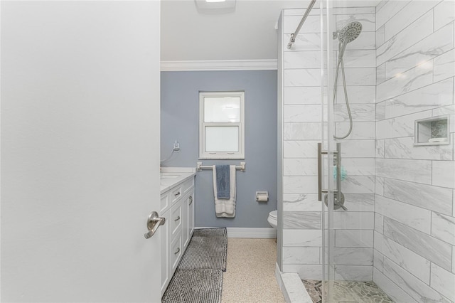 bathroom featuring a tile shower, vanity, toilet, and crown molding