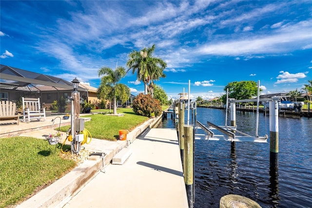 view of dock with a lawn and a water view