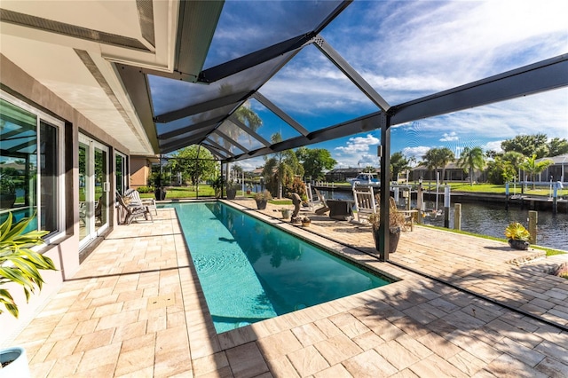 view of pool featuring a lanai, a patio area, a water view, and a boat dock