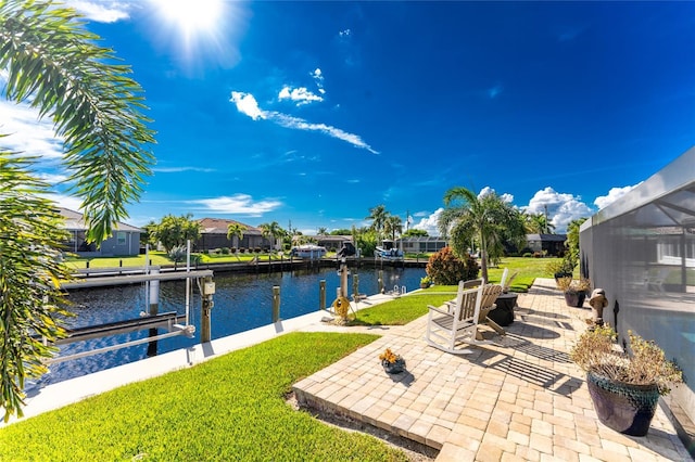 exterior space with a boat dock, a water view, glass enclosure, and a patio area