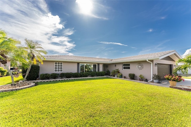 ranch-style house featuring a garage and a front lawn