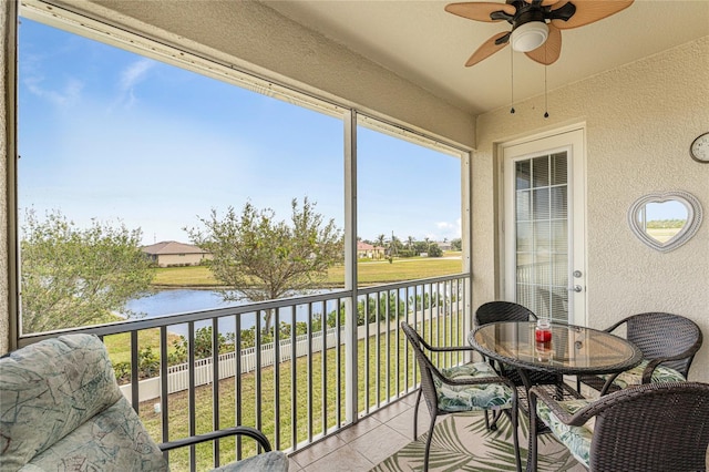 sunroom / solarium featuring a water view and ceiling fan