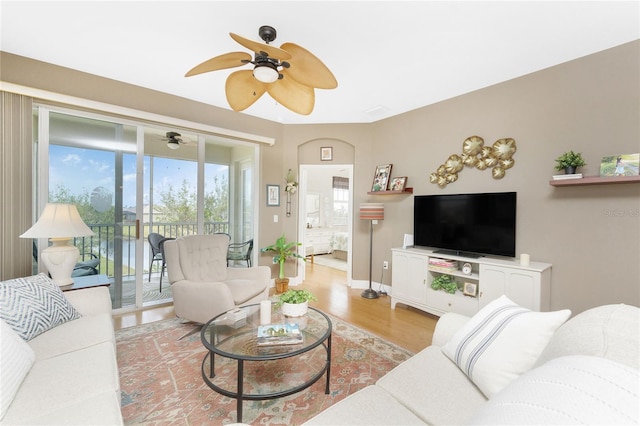 living room with ceiling fan and light hardwood / wood-style flooring