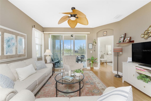 living room with ceiling fan and light hardwood / wood-style flooring